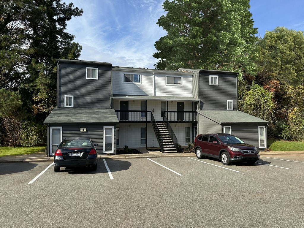 a large apartment building with cars parked in a parking lot