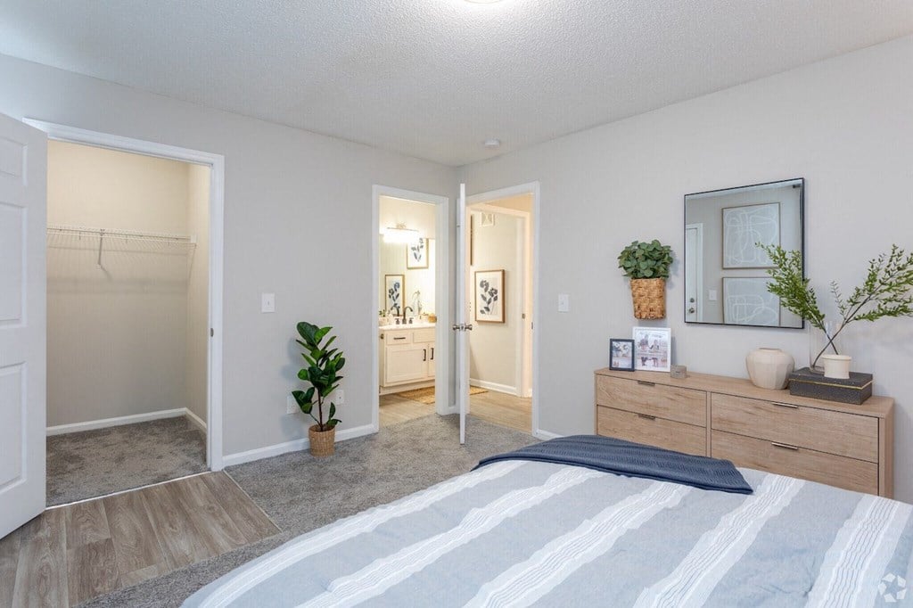 a bedroom with a bed and a closet and a bathroom