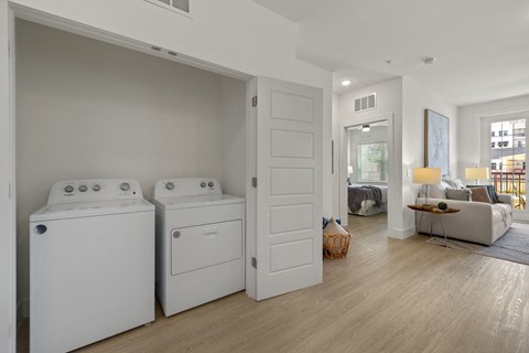 a washer and dryer in a room with a living room and a bedroom