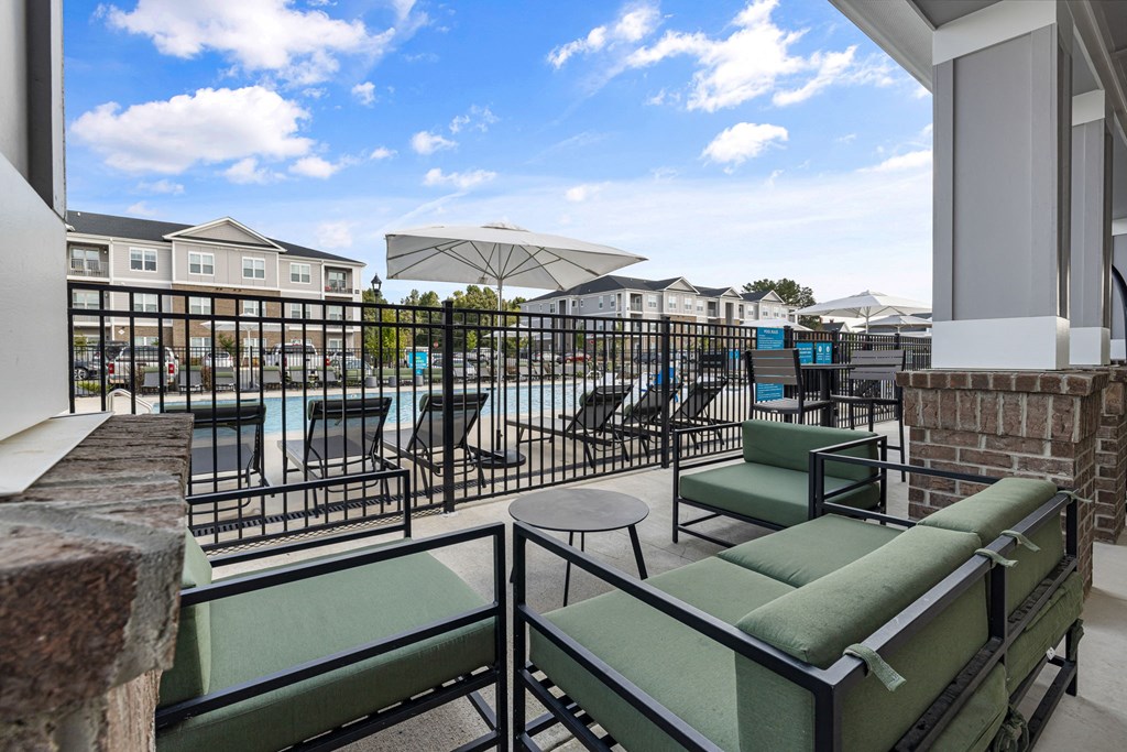 a balcony with a pool and chairs and tables