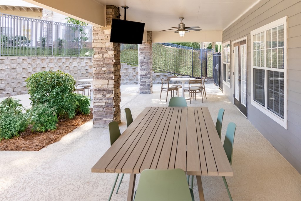 a patio with a table and chairs and a television