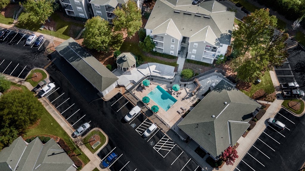 an aerial view of a house with a pool and parking lot