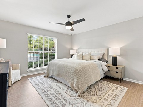 A bedroom with a large bed and a ceiling fan.