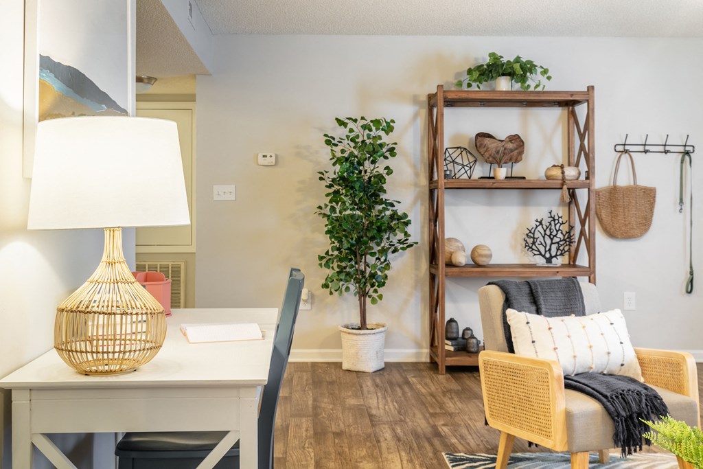a living room with a desk and a chair and a plant