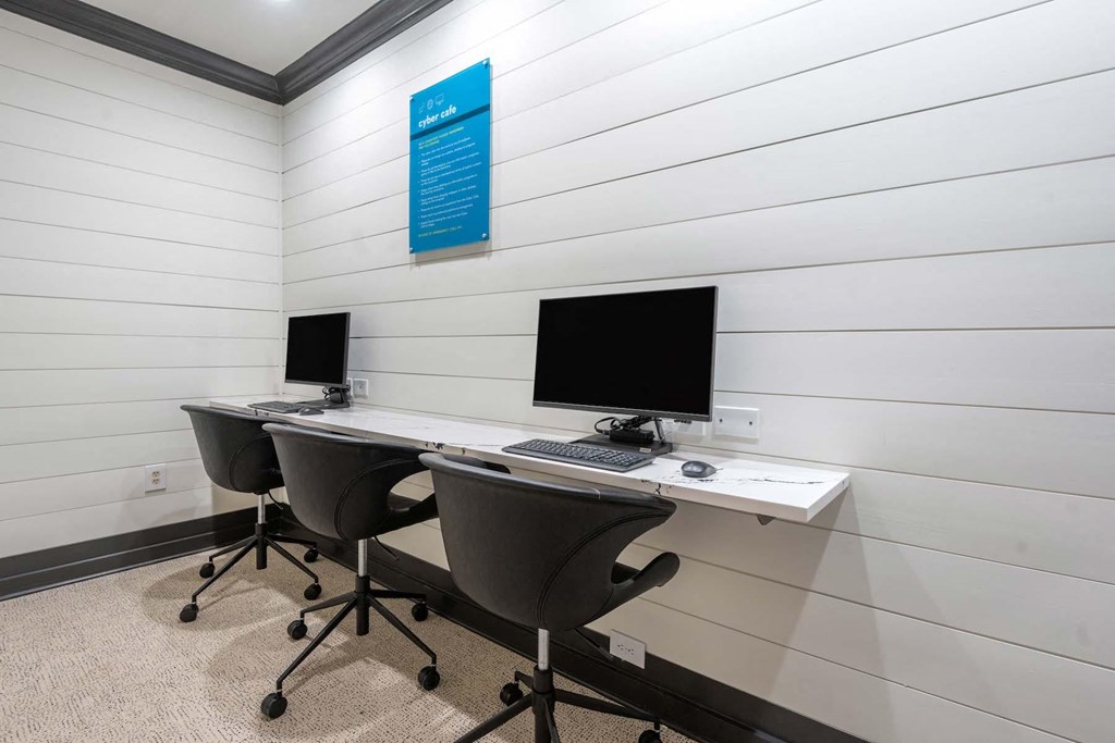 a conference room with two desks and two computer monitors
