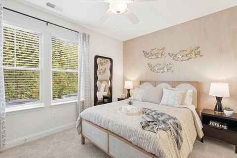 A bedroom with a large bed and a ceiling fan.