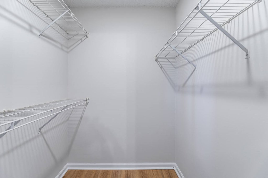 Empty silver shelves in a white room.