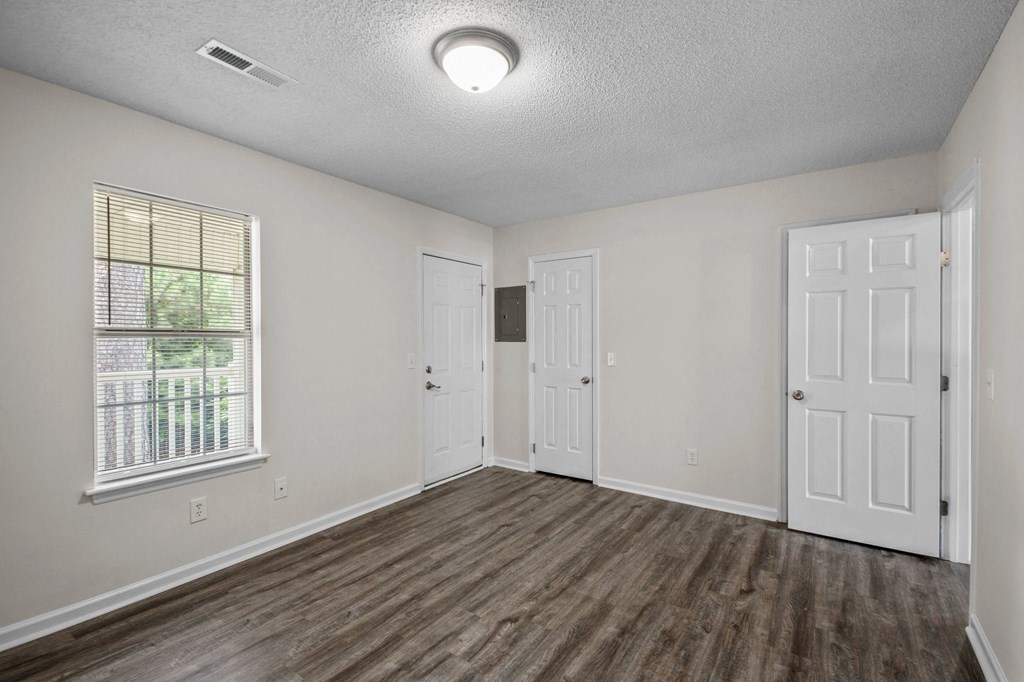 an empty living room with white walls and wood flooring