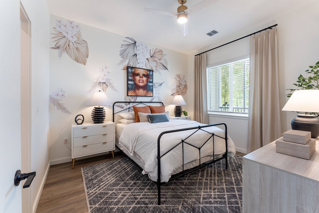 A bedroom with a bed, nightstand, and a wall decoration.