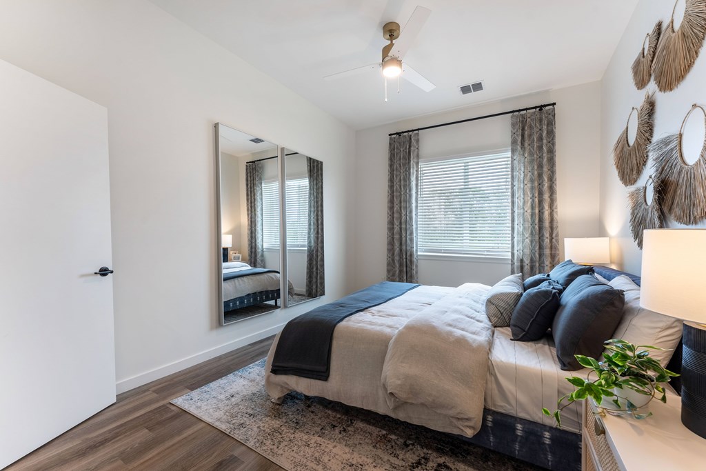 A bedroom with a large bed and a mirror on the wall.