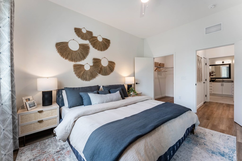 A bedroom with a large bed and a mirror on the wall.