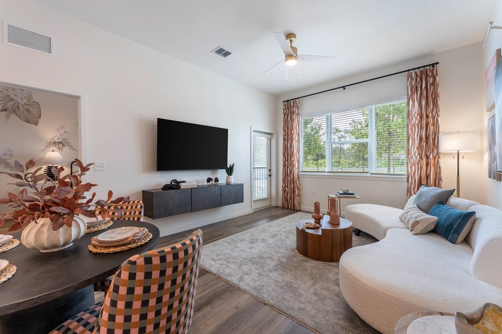 A modern living room with a black and white checkered chair and a flat screen TV.