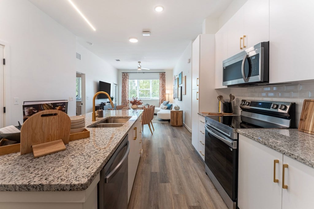 A modern kitchen with granite countertops and stainless steel appliances.
