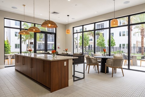 A kitchen with a table and chairs and a counter with a sink.