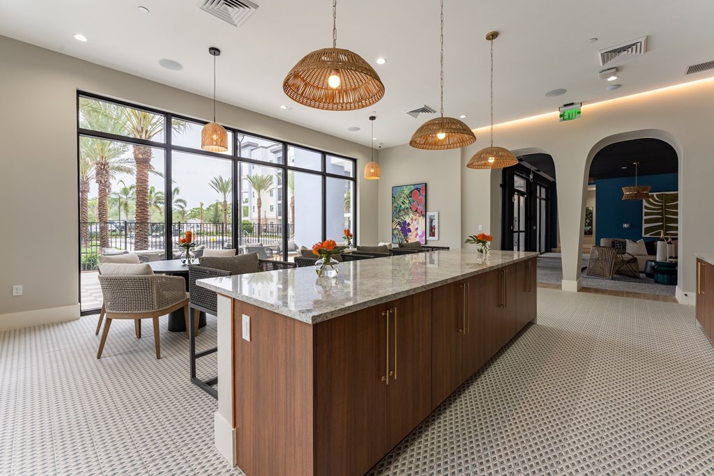 A kitchen with a large island and a dining table with chairs.