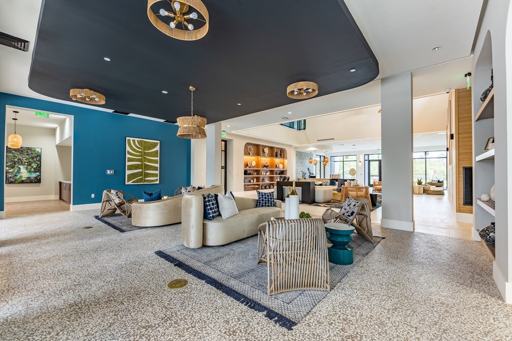 A living room with a blue accent wall and a large area rug.