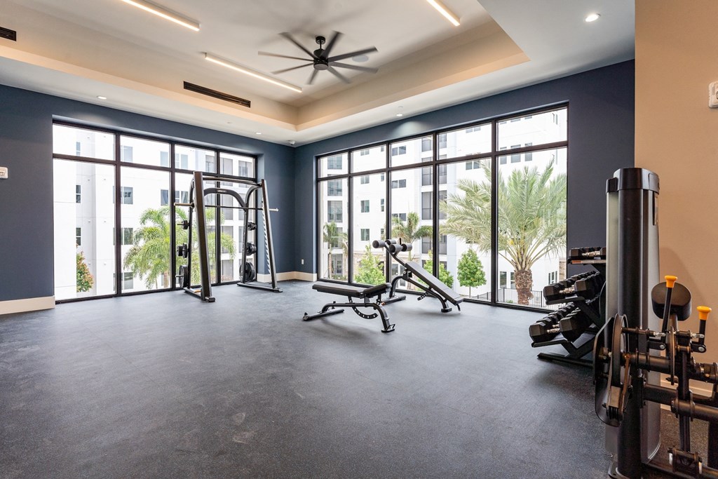 A spacious gym with a variety of equipment and a view of the outside.