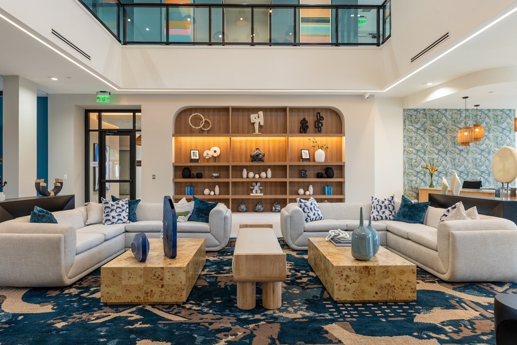 A living room with a blue carpet and white furniture.