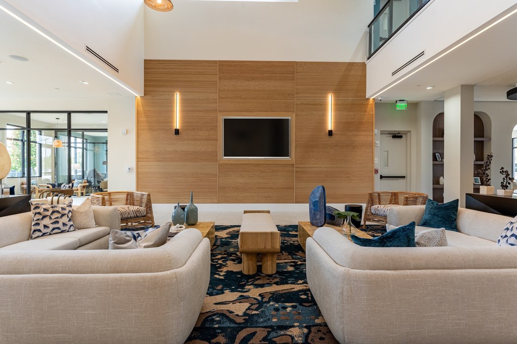 A living room with a large couch and a television mounted on the wall.