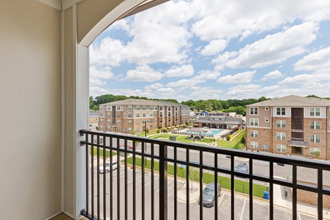 A balcony view of a residential area with cars and buildings.