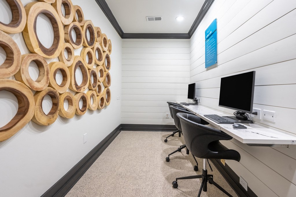 a home office with a desk with a computer and a wall with a wall installation