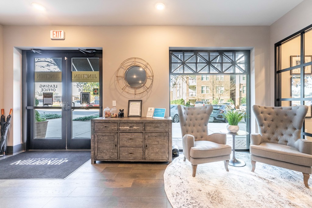 a lobby with two chairs and a table and a glass door