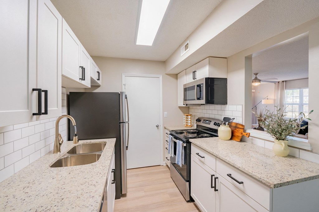 an open kitchen with granite counter tops and stainless steel appliances