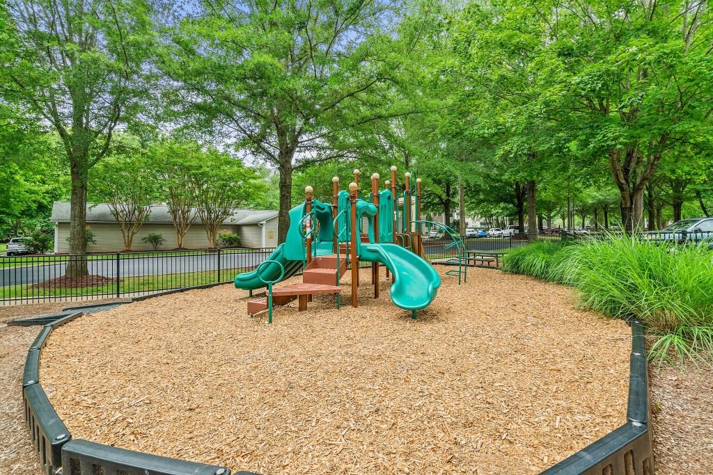 a playground with slides and benches in a park