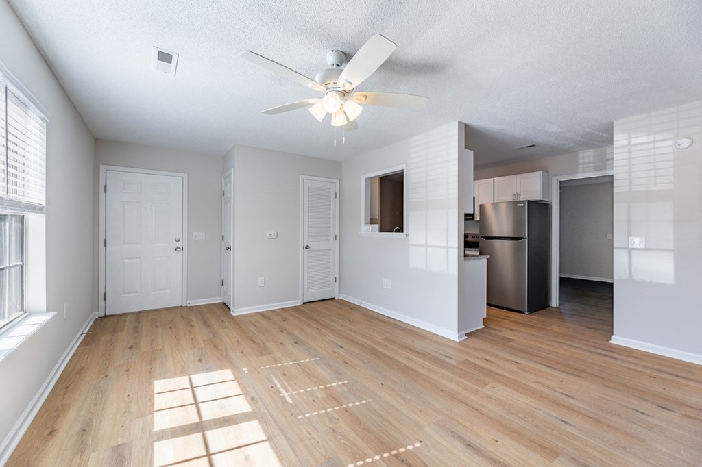 A room with a ceiling fan and wooden flooring.