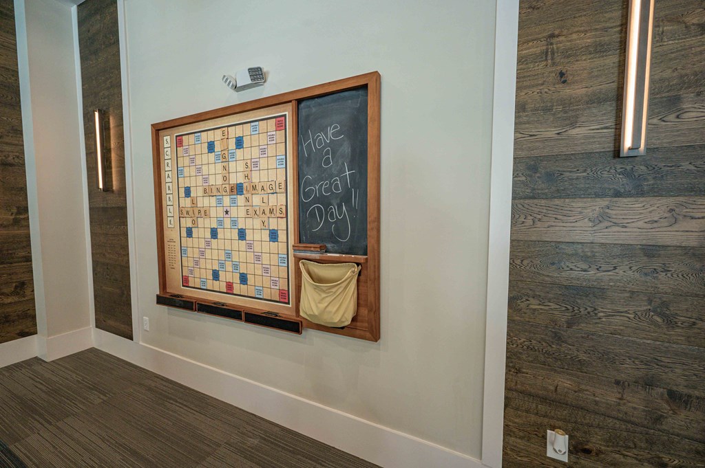 a bulletin board on the wall in a room with a chalkboard and a sign