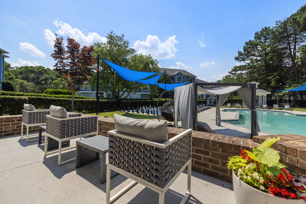 a patio with chairs and a pool in a backyard