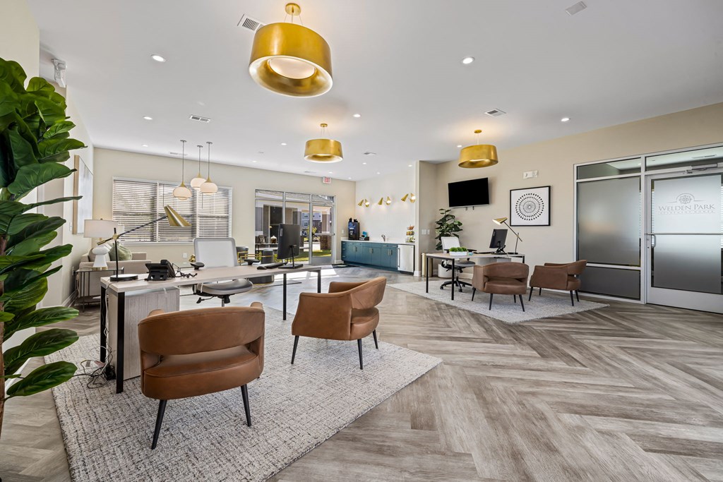 a lobby with chairs and tables and a kitchen and living room