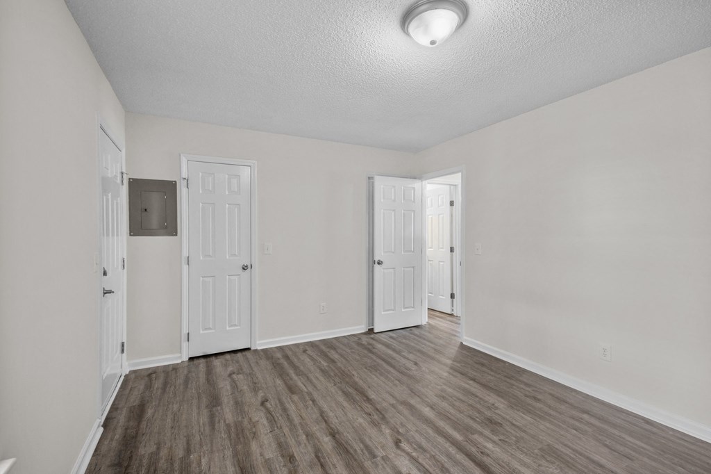 the living room of our studio apartment atrium with white walls and wood flooring