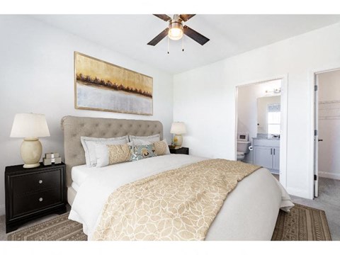 A bedroom with a large bed and a painting on the wall.