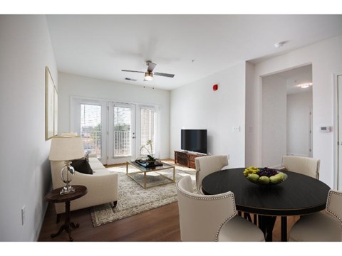 A living room with a black table and white chairs.