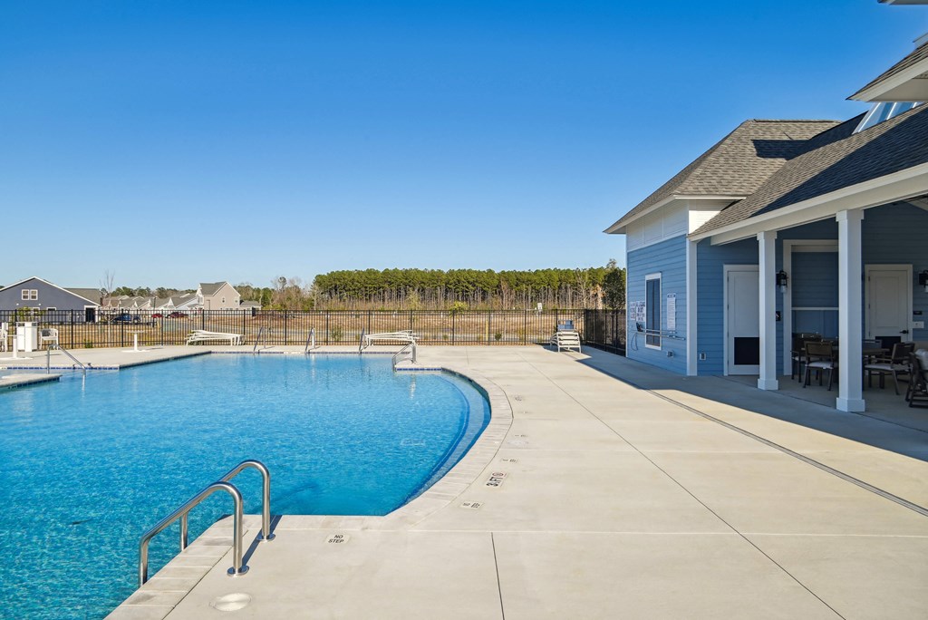 A large swimming pool in front of a pool house at 15 at Heron in Longs, SC.