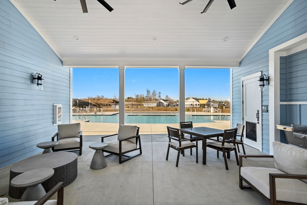 An outside patio with a pool and patio furniture at 15 at Heron in Longs, SC.