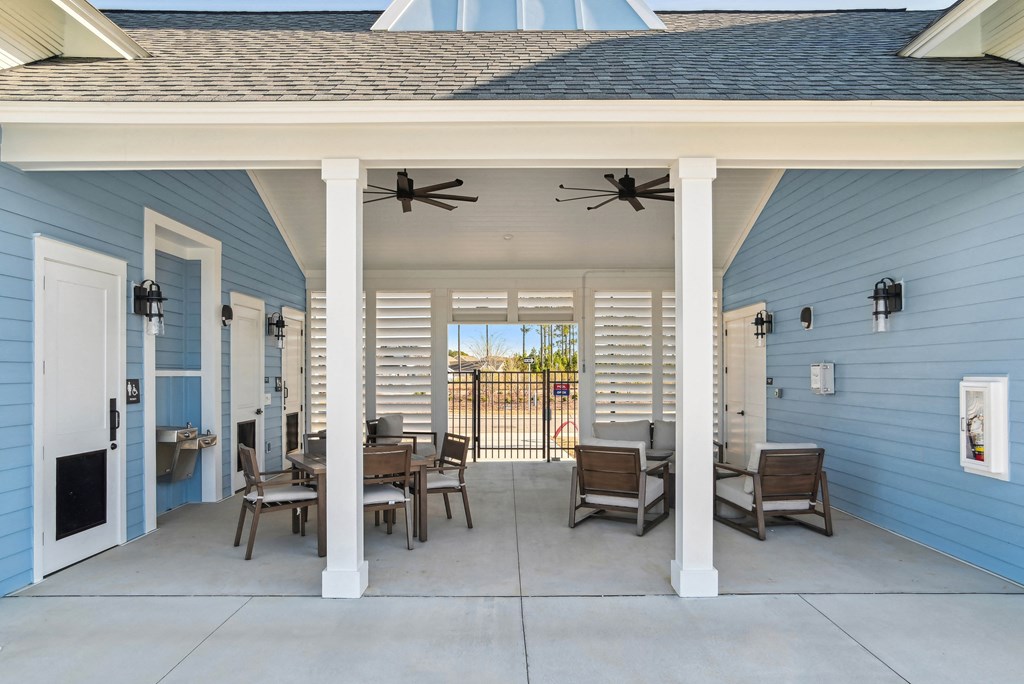 A covered outside patio with a pool and patio furniture at 15 at Heron apartments in Longs, SC.