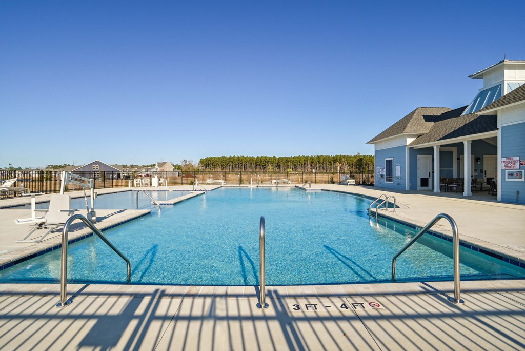 A large swimming pool in front of a pool house at 15 at Heron in Longs, SC.