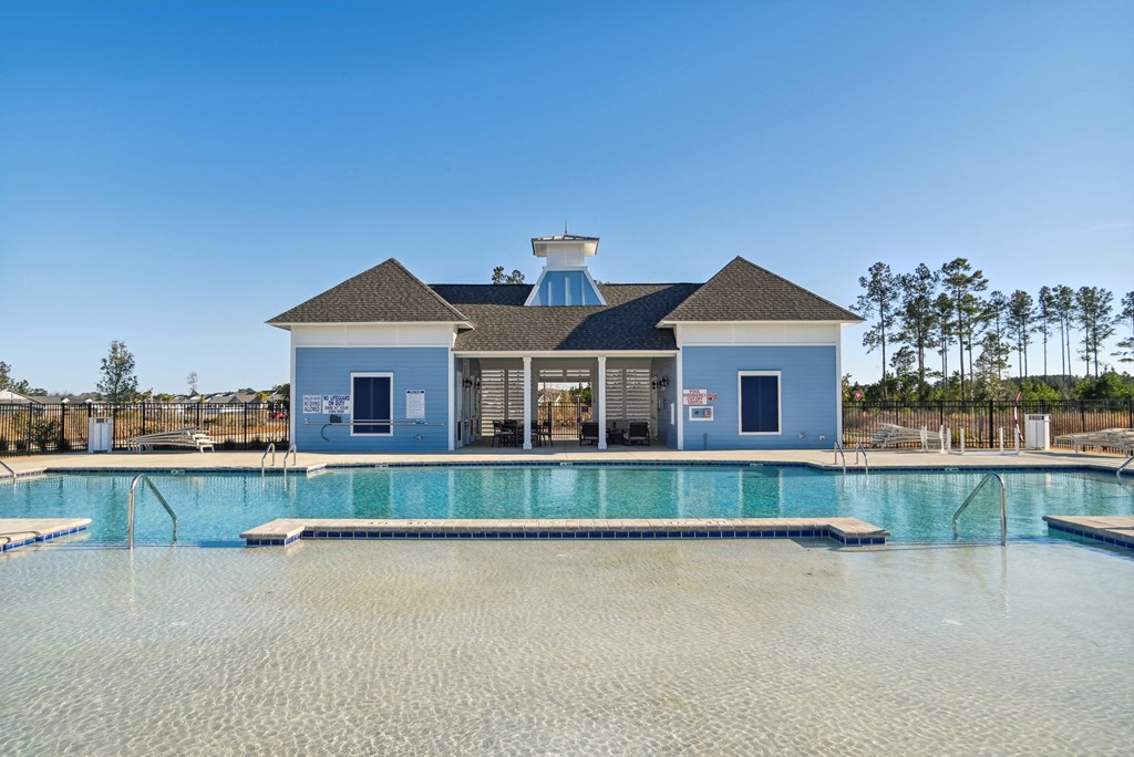 A large swimming pool in front of a pool house at 15 at Heron in Longs, SC.