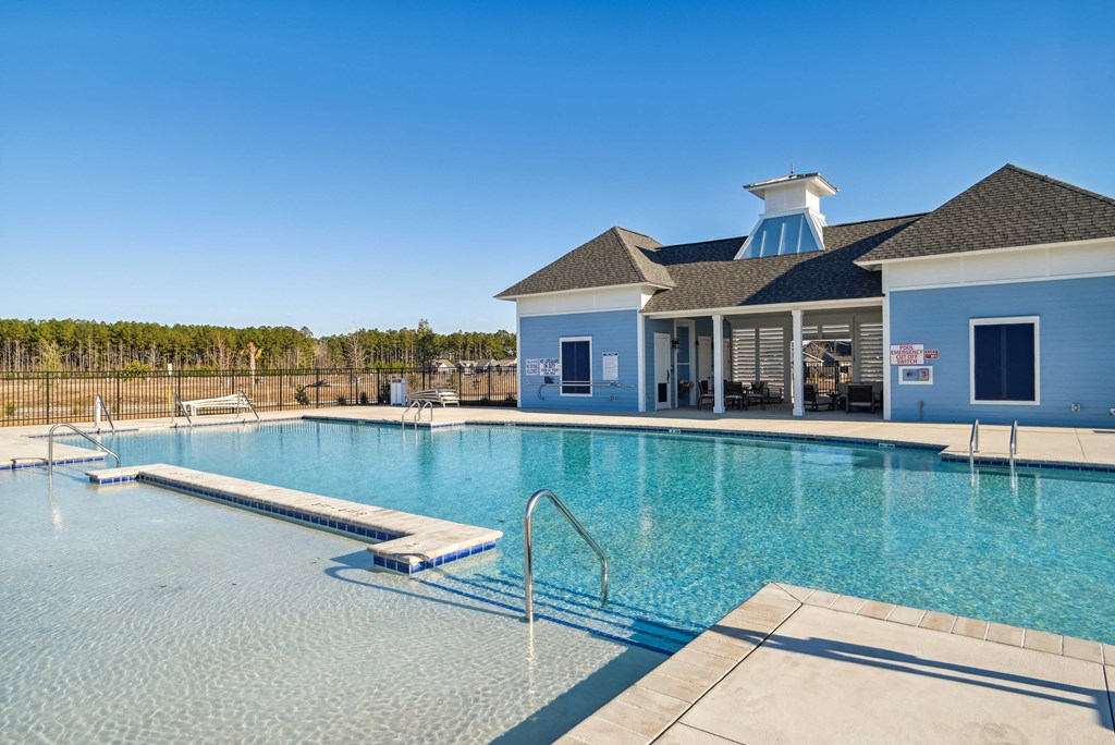 A large swimming pool in front of a pool house at 15 at Heron in Longs, SC.