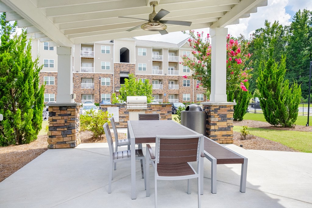 a patio with a table and chairs and a fan