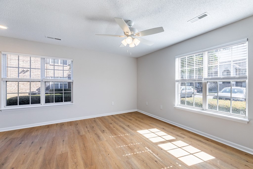 A room with a ceiling fan and wooden flooring.