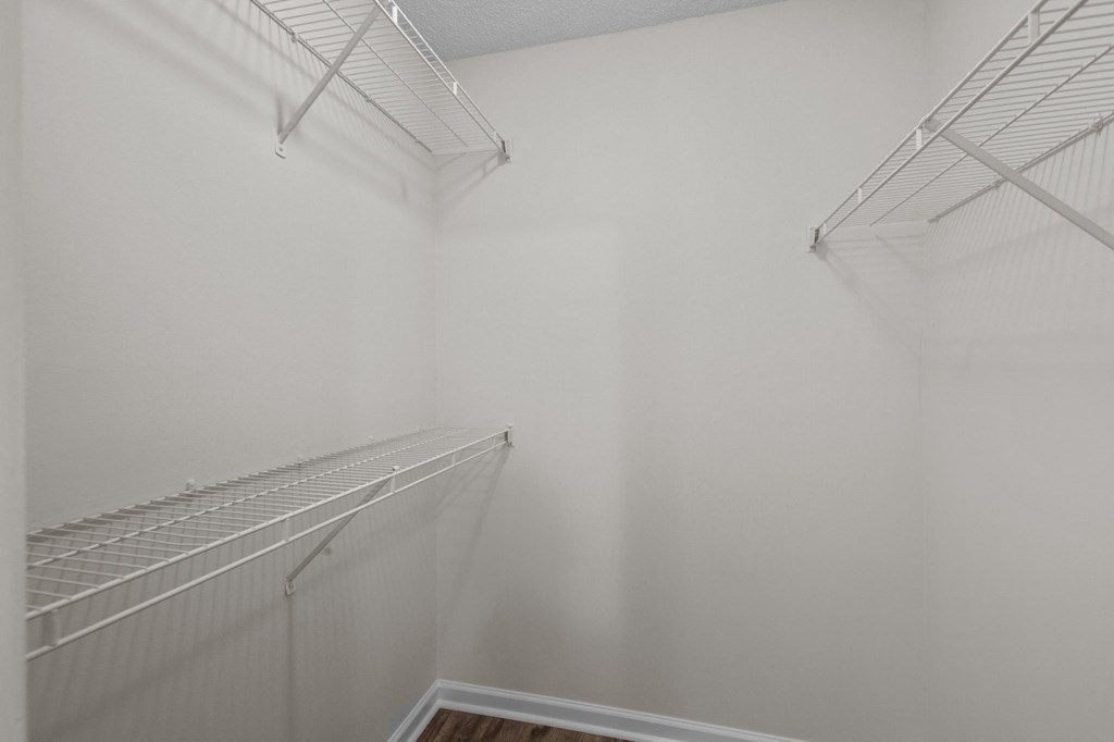 room with white walls and shelves and a closet with hanging racks