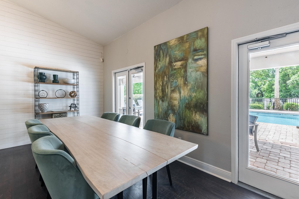 a dining room with a table and chairs and a sliding glass door to a pool