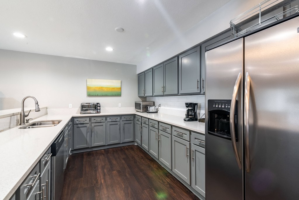 a modern kitchen with stainless steel appliances and white counter tops