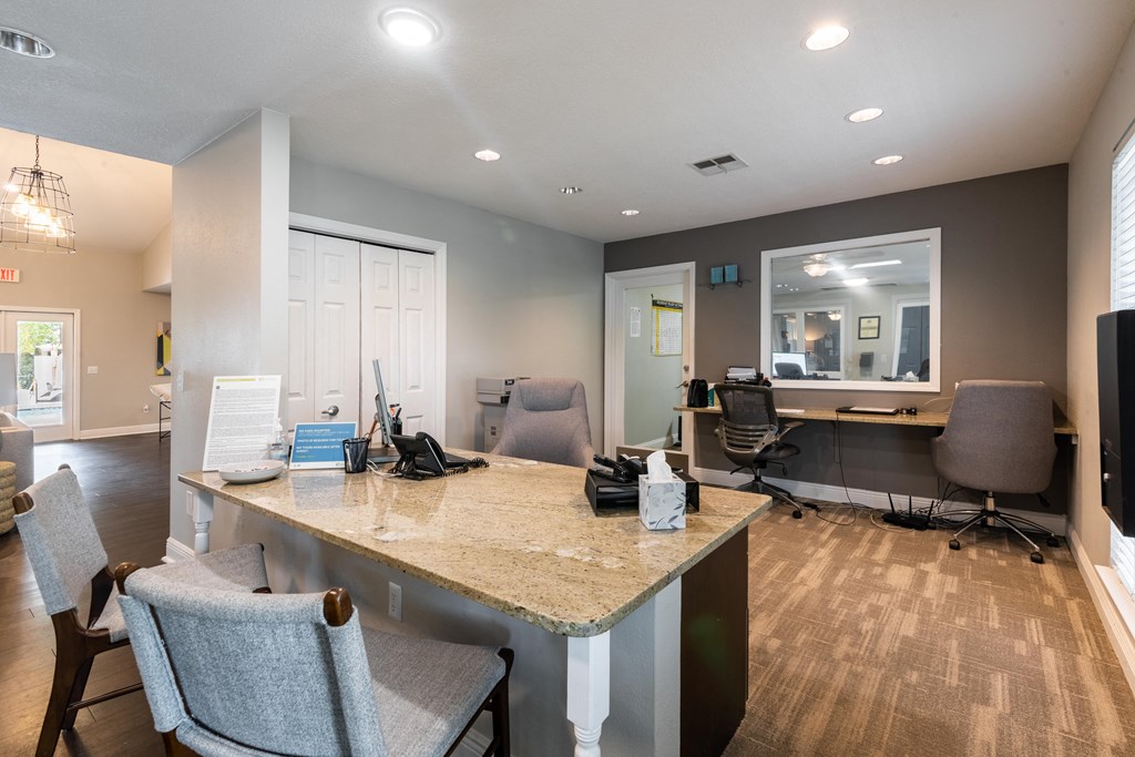 an office with a desk and chairs and a window