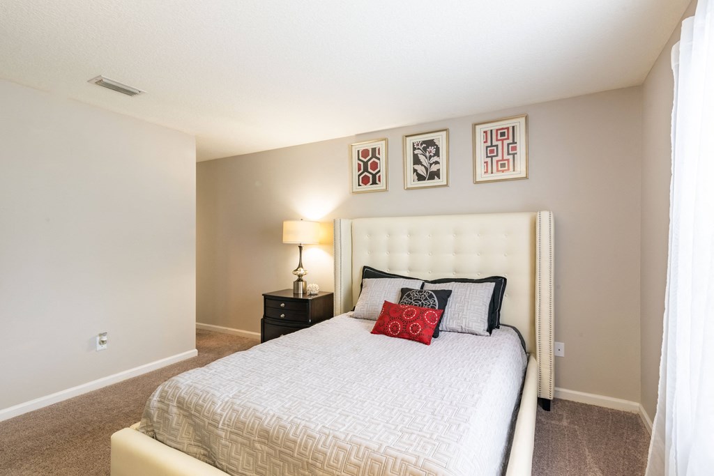 the preserve at ballantyne commons bedroom with white bed and framed pictures