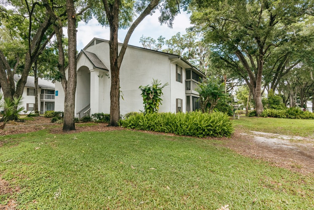 a white house with trees and grass in front of it