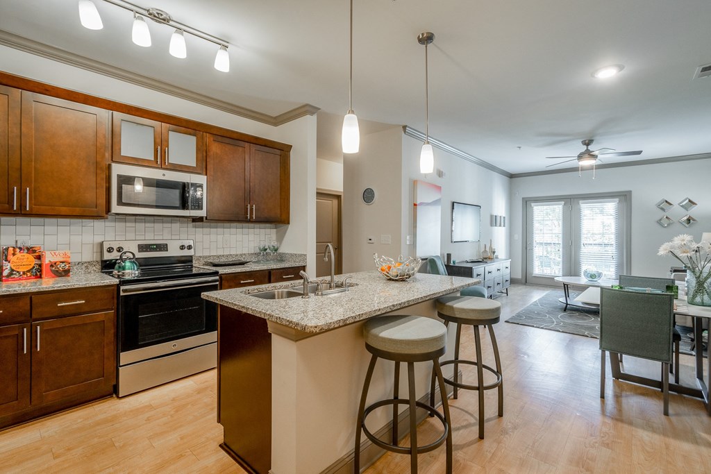 an open kitchen and living room with an island with stools